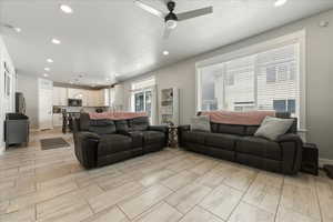 Living area featuring recessed lighting, a ceiling fan, a textured ceiling, and wood tiled floors
