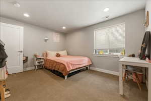 Bedroom with light colored carpet and recessed lighting