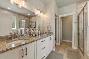 Primary bathroom featuring double vanity and a stall shower