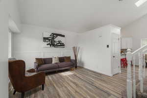 Living room with light wood-type flooring and lofted ceiling
