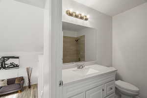 Bathroom with vanity, a tile shower, and light wood-type flooring