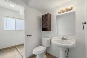 Half bathroom featuring toilet and baseboards