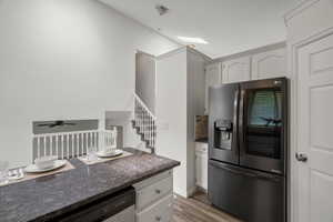 Kitchen featuring stainless steel appliances, light wood finished floors, a skylight, and white cabinets