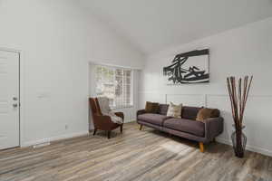 Sitting room with vaulted ceiling and light wood finished floors