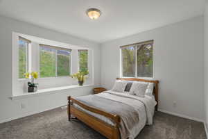 Bedroom featuring dark carpet and baseboards