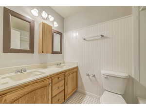 Full bath featuring double vanity and light tile patterned floors