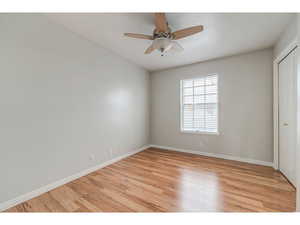Unfurnished bedroom with a ceiling fan, light wood-style floors, and a closet