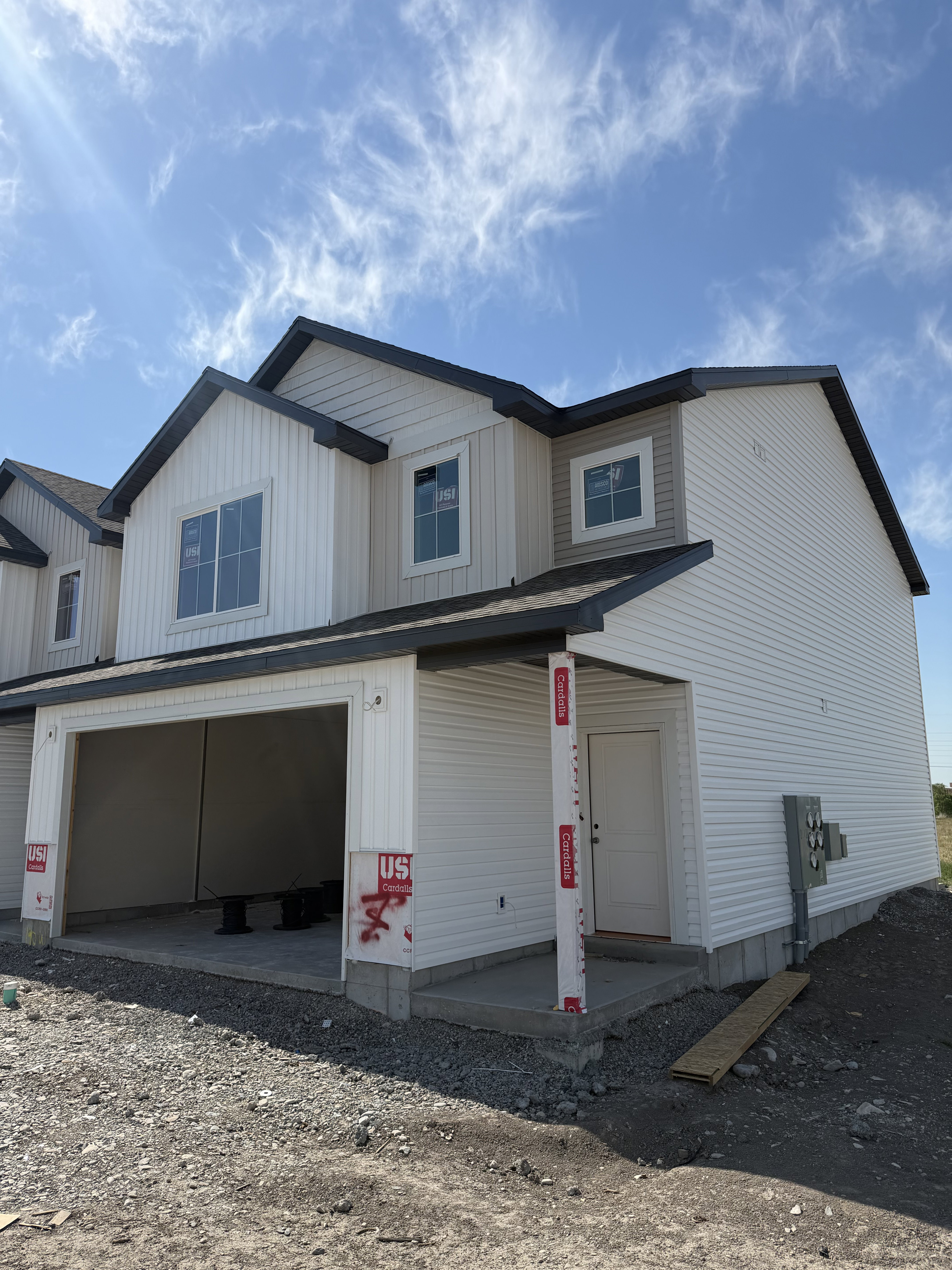 Two-story exterior featuring white vertical and horizontal siding
