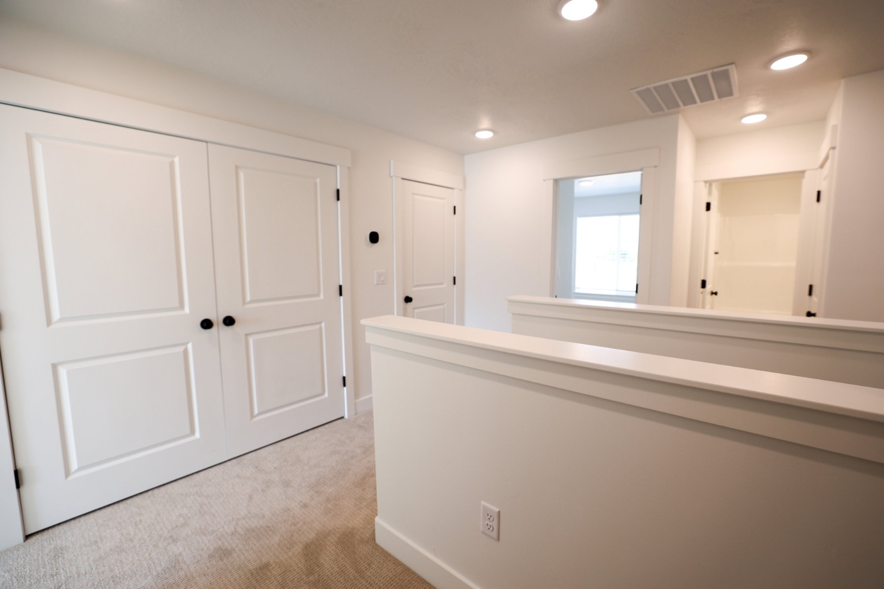 Hall featuring recessed lighting, light colored carpet, and an upstairs landing