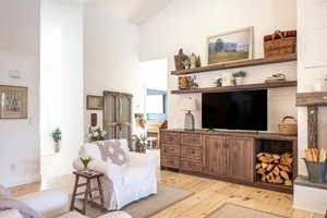 Living room with light wood-type flooring and vaulted ceiling