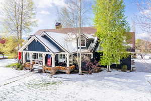 View of front of home with covered porch, board and batten siding, and a chimney