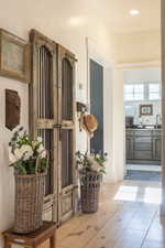 Hall with light wood finished floors and recessed lighting