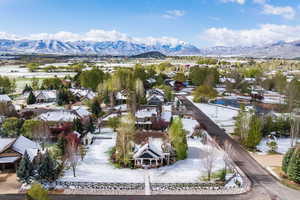 Snowy aerial view featuring a mountain view and a residential view