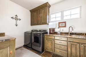 Laundry room featuring cabinet space, separate washer and dryer, and dark wood-type flooring