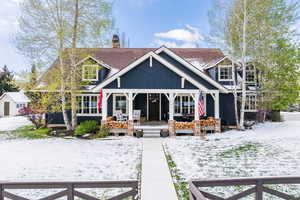 Craftsman house featuring covered porch, a chimney, and a shingled roof