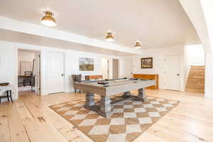 Game room featuring light wood-style floors and billiards