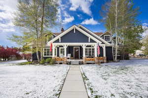 Craftsman-style home featuring covered porch and a chimney