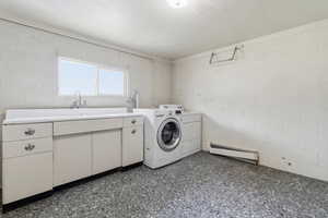 Laundry area featuring washer / clothes dryer, baseboard heating, and cabinet space