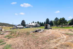 View of yard with a view of countryside and a storage shed
