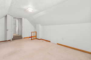 Bonus room featuring a textured ceiling and carpet
