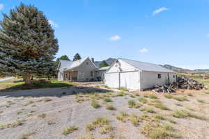 View of side of property featuring a mountain view, a metal roof, and a porch