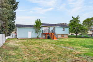 Rear view of property featuring stairs and a fenced backyard