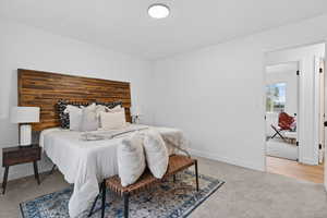 Bedroom featuring light carpet and baseboards