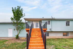 Rear view of house with stairway and a yard