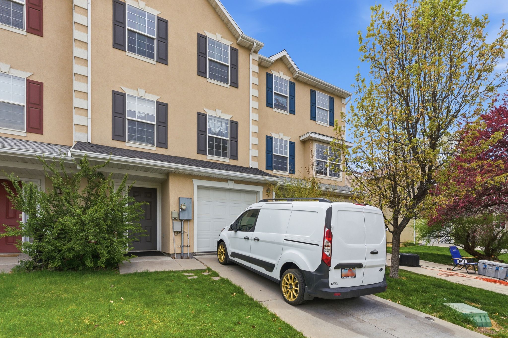 View of front facade featuring stucco siding, a garage, concrete driveway, and a front lawn