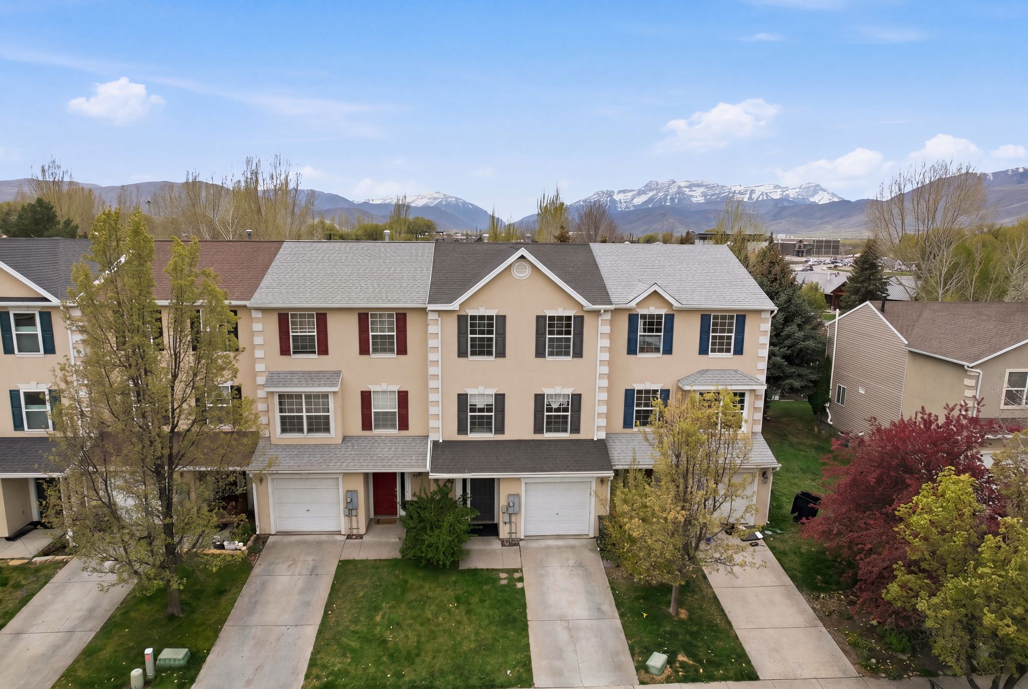 View of front of home with a mountain view, concrete driveway, roof with shingles, a front lawn, and a garage