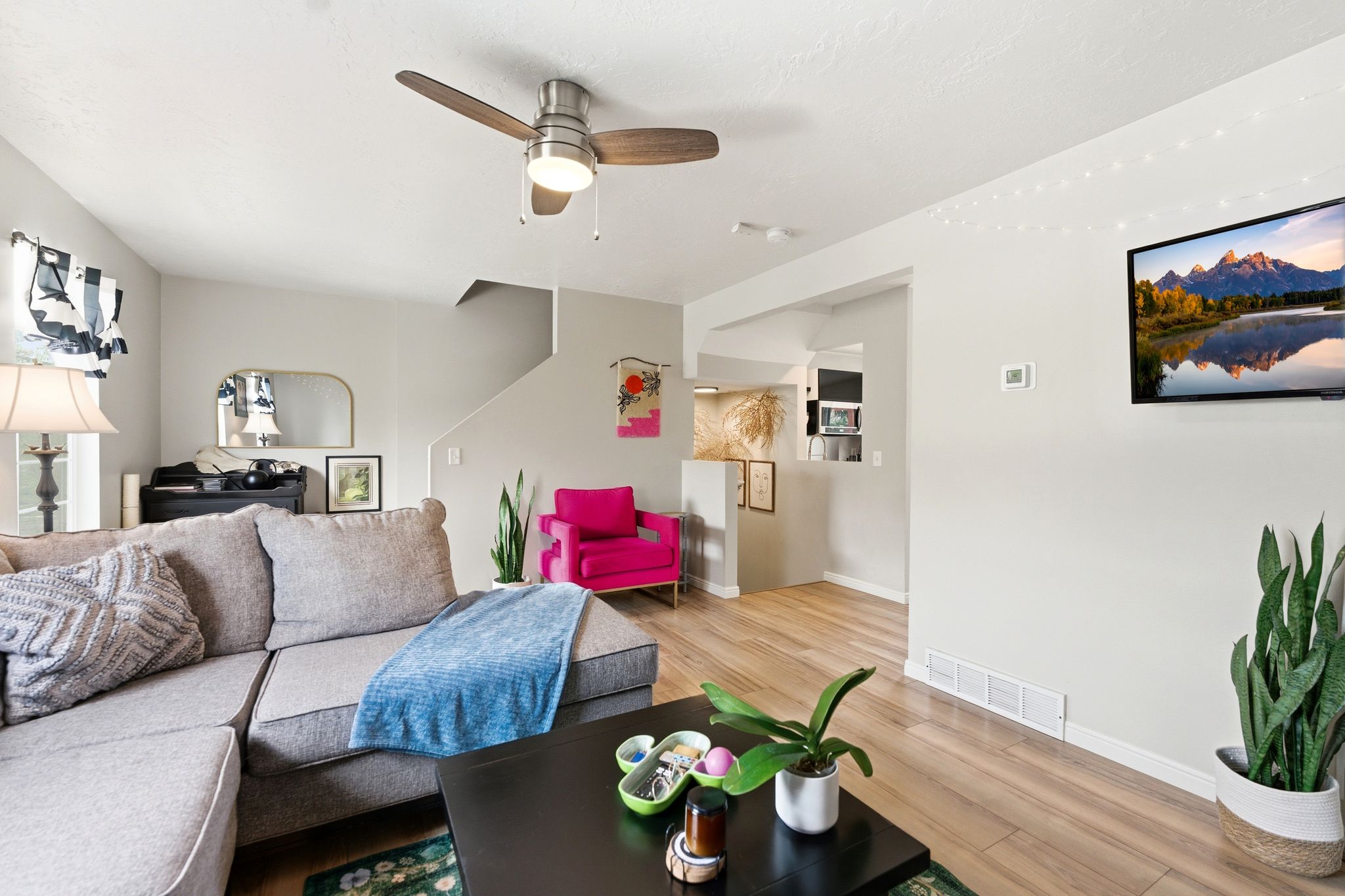 Living room with a ceiling fan and light wood finished floors