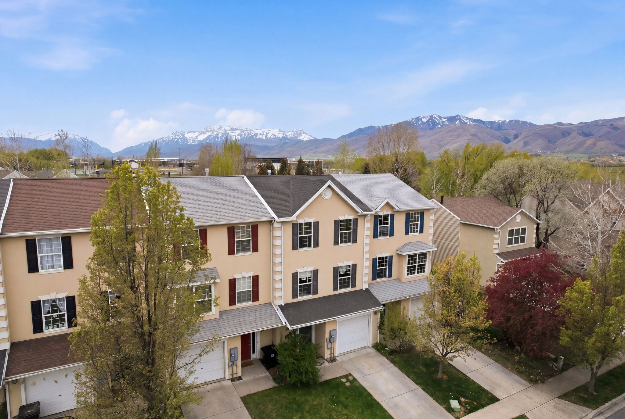 View of front facade featuring concrete driveway, stucco siding, a mountain view, a garage, and a shingled roof