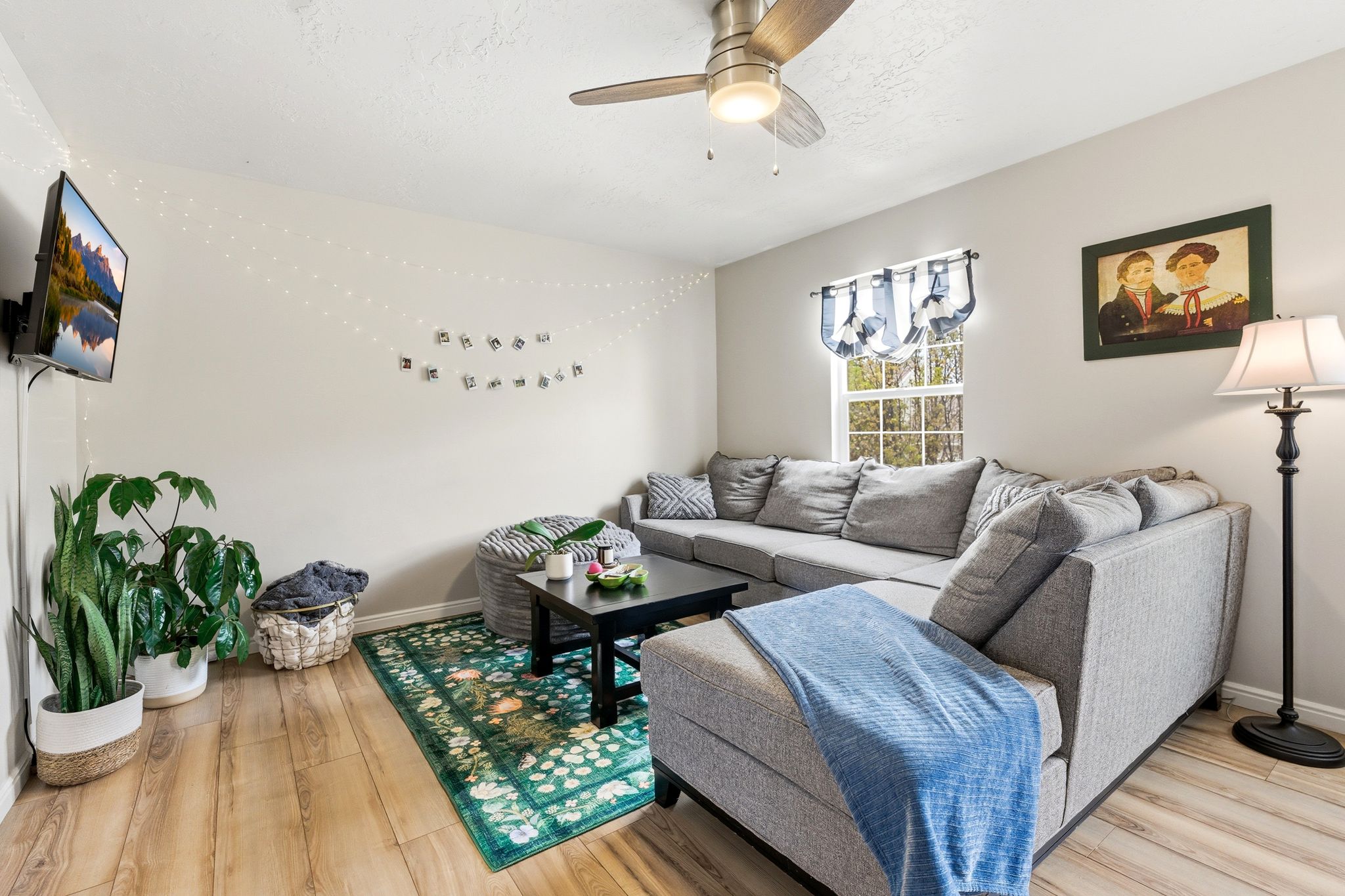 Living area with light wood-style floors and ceiling fan