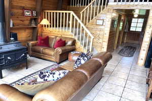 Living room with wood walls and a wood stove