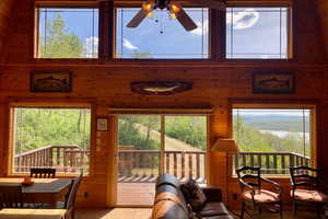 Living room with wood walls, a ceiling fan, and a mountain view