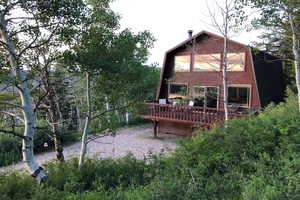 Rear view of house with a gambrel roof and a deck