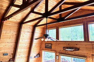 Detailed view of a wood ceiling with exposed beams and wooden walls