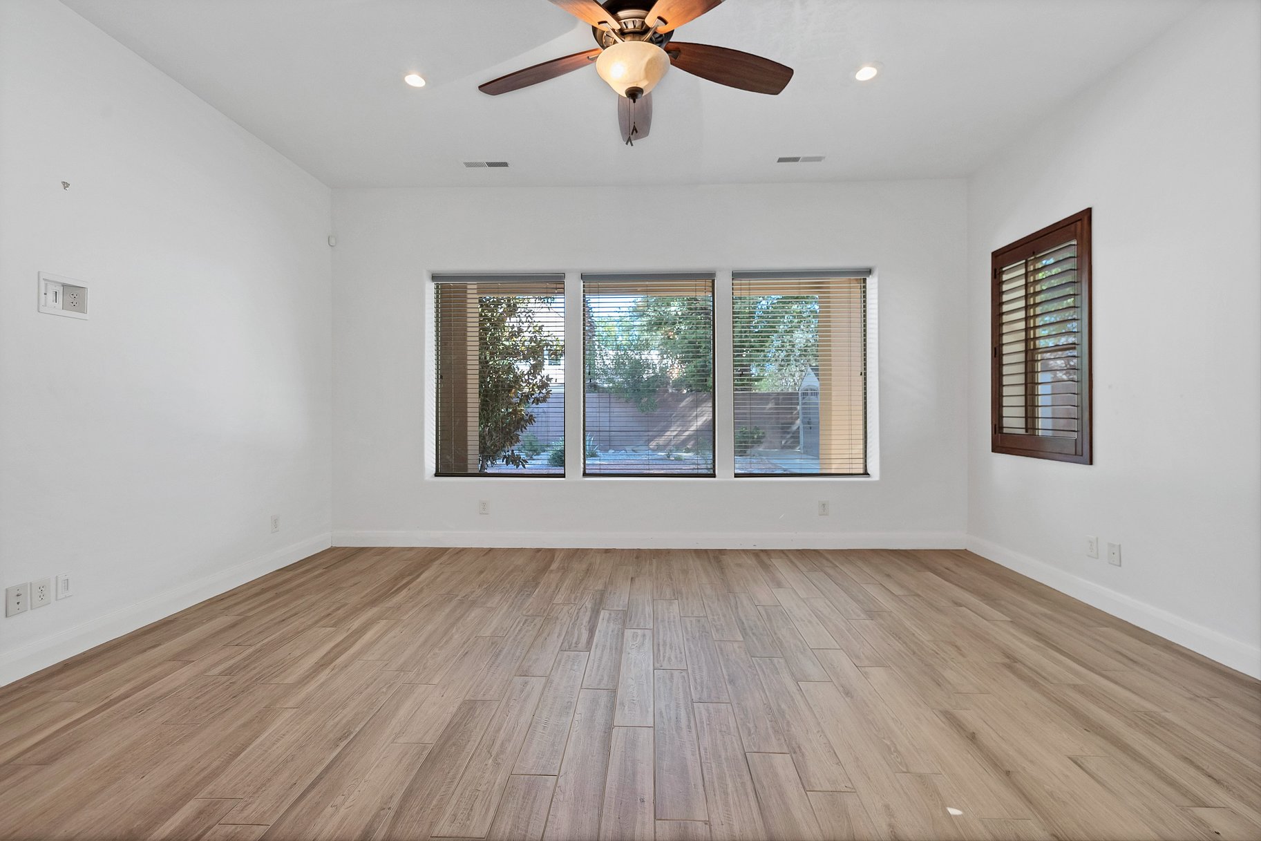 Empty room featuring ceiling fan, light wood finished floors, and recessed lighting