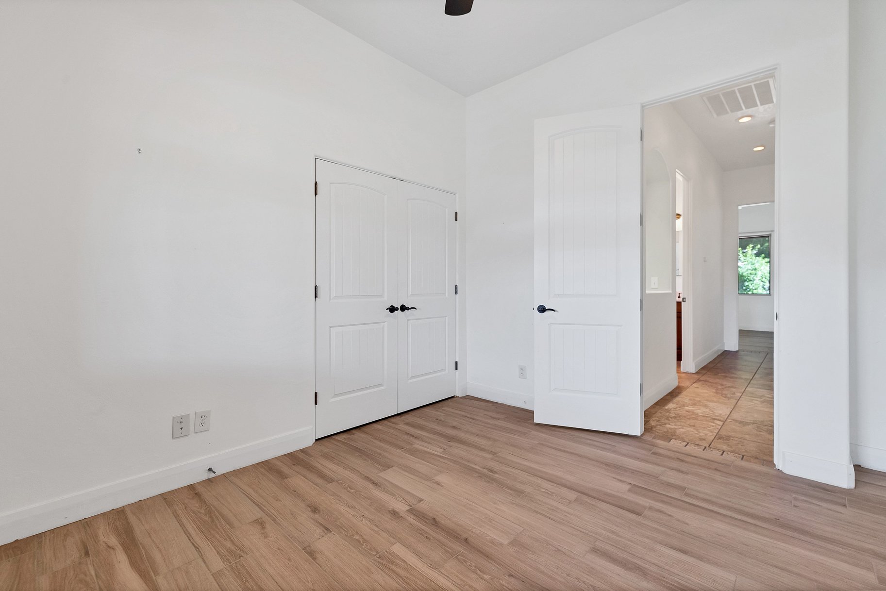 Unfurnished bedroom featuring light wood finished floors, vaulted ceiling, a closet, and ceiling fan