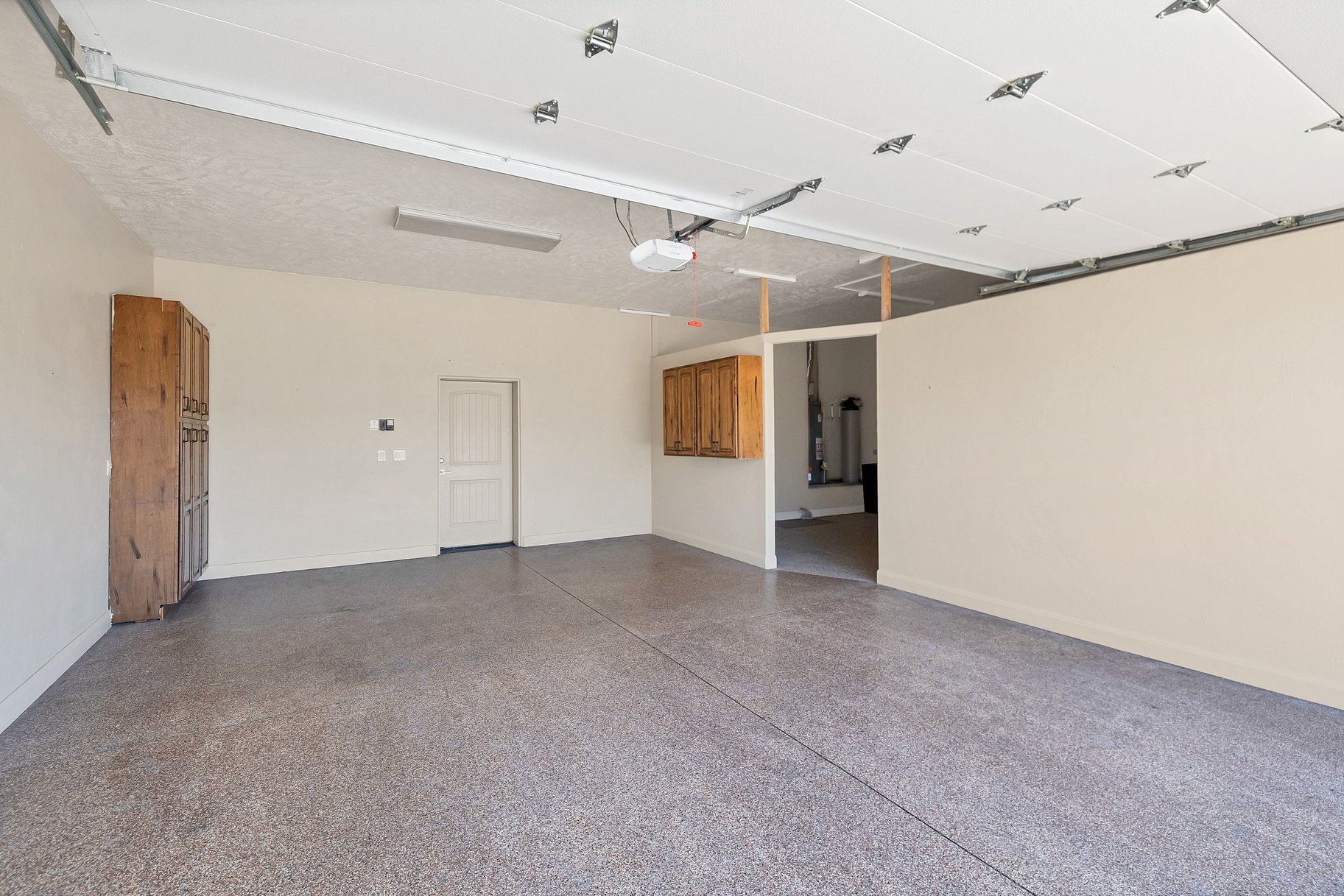 Garage with baseboards and a garage door opener