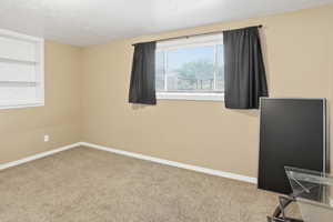 Spare room featuring carpet flooring and baseboards