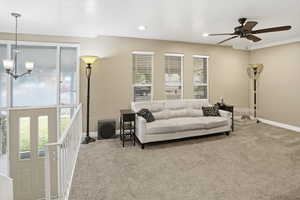 Living area featuring carpet, ceiling fan.