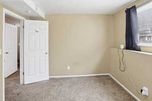 Bedroom with a textured ceiling and carpet