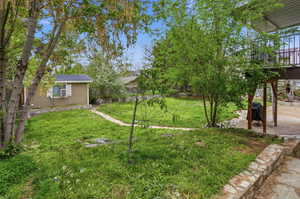 View of grassy yard featuring an outbuilding