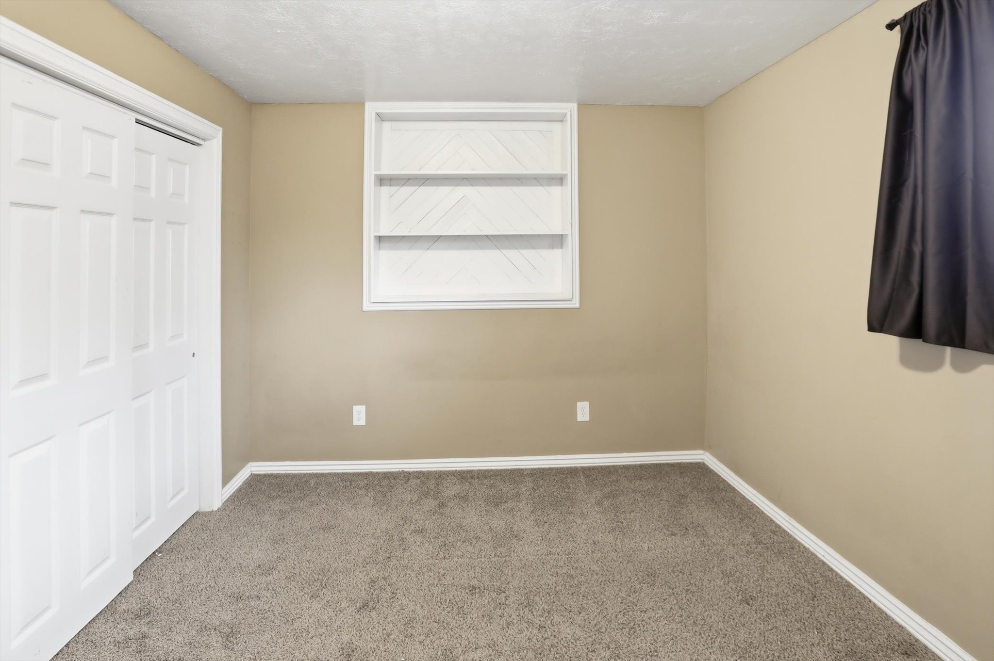 Bedroom with carpet floors, a textured ceiling, and a closet