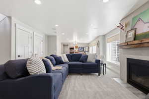 Living room featuring a high end fireplace, light carpet, and recessed lighting