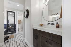 Bathroom featuring vanity, recessed lighting, a stall shower, and light flooring