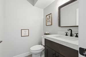 Half bathroom featuring vanity and toilet