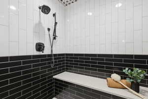 Full bathroom with tiled shower and tile walls