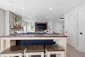 Kitchen featuring built in features, wood counters, recessed lighting, a kitchen bar, and open floor plan